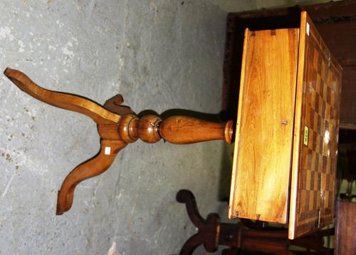 A 19th century Continental fruitwood and rosewood inlaid games/ work table, the chessboard inlaid top revealing a fitted interior, on tripod base, 38c