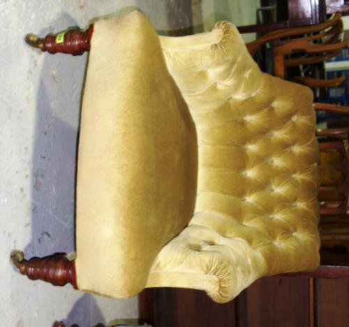 A 19th century walnut framed green upholstered button back tub armchair.