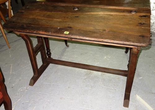 A 20th century continental oak two seated slope top school desk, 110 cm wide.