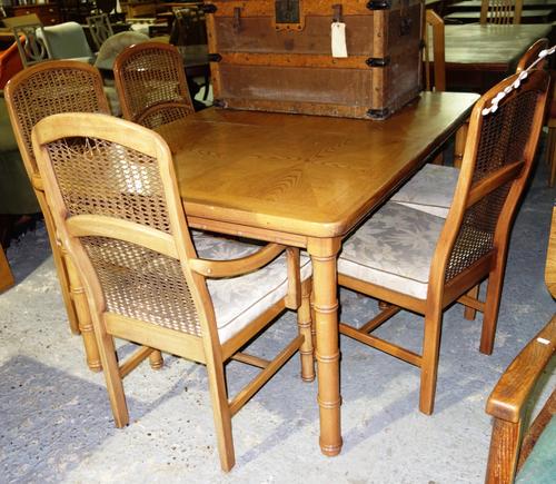 A 20th century oak extending dining table with faux bamboo supports, 198cm wide extended, together with six oak and cane chairs. (7)