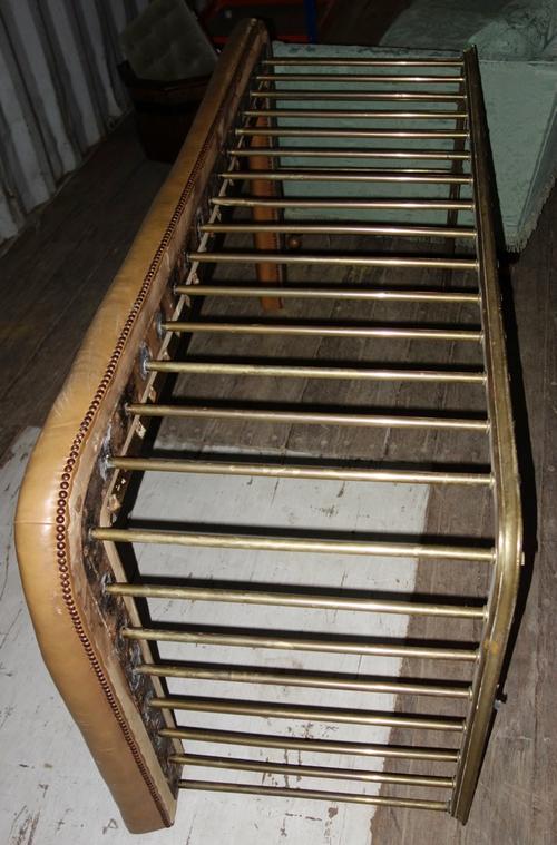 A 19th century brass and leather club fender.