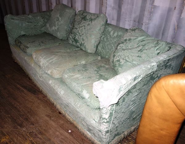 A celedon green upholstered sofa.