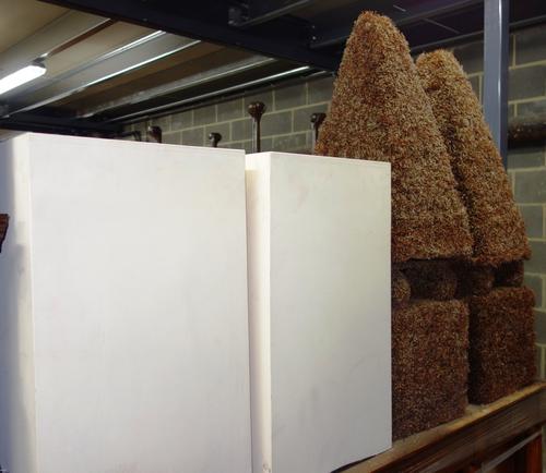 A pair of faux box hedges formed as obelisks and two grey painted decorative spiral reeds (4)