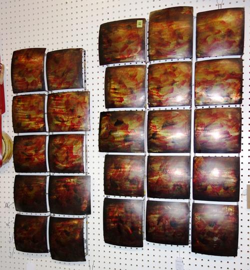 Two similar 20th century decorative metal wall panels with orange, red and yellow decoration. (2)