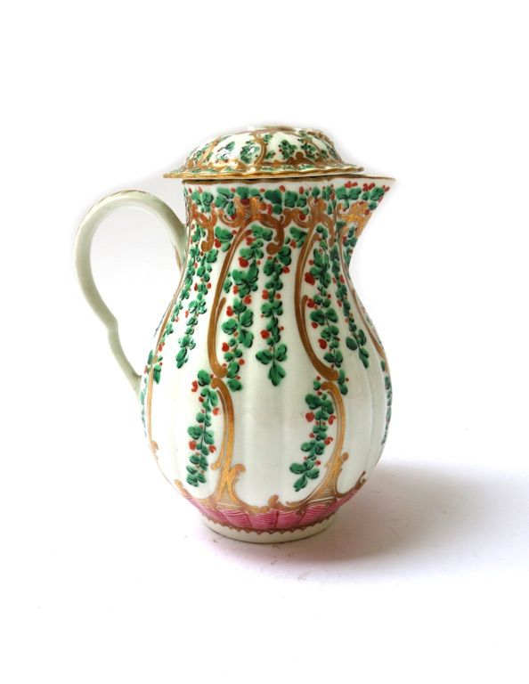 A Worcester porcelain pear shaped milk jug and cover, circa 1770, painted with hops and berries above a pink chevron border, (a.f), 12cm high.