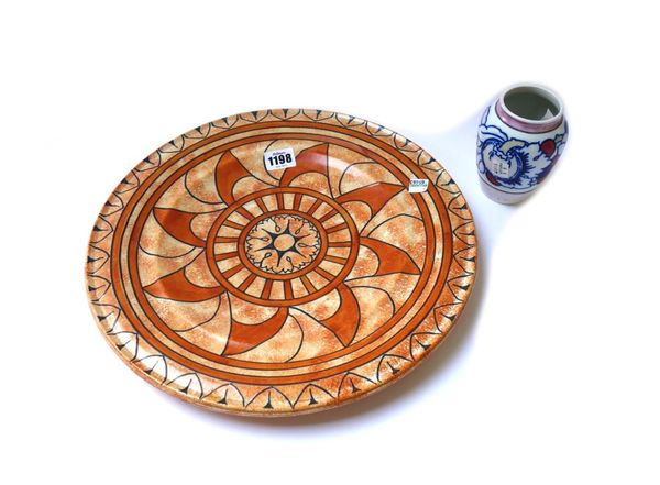 A Burleigh Ware charger designed by Charlotte Rhead, tube lined and decoated with the `Florentine' pattern, 4752, in shades of brown, 35.5cm. diameter