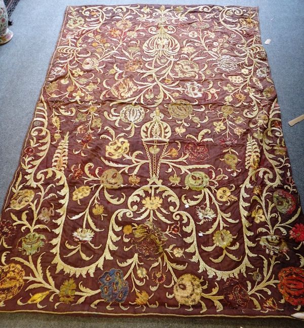A large Ottoman embroidered silk hanging, worked in high relief with floral designs against a deep red ground, (a.f), 233cm. by 153cm.
