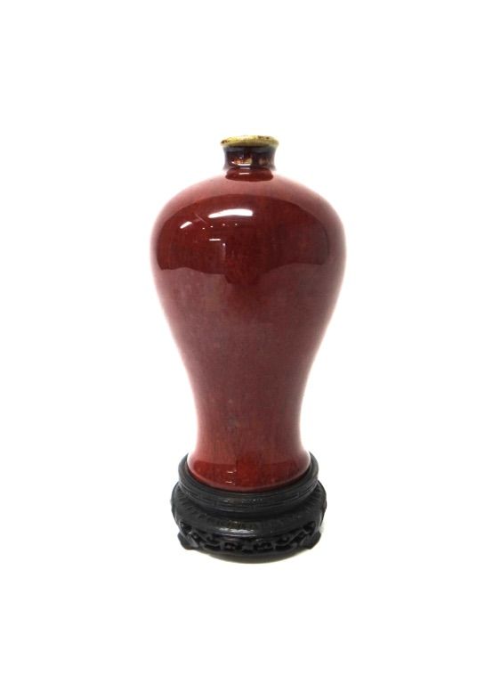 A small Chinese flambé vase, Qing Dynasty, 18th/19th century, of baluster form, covered in a deep red glaze, 15.5cm.high, wood stand.