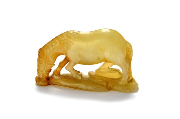 A Chinese grey and russet jade figure of a horse, Qing Dynasty, 18th/19th century, carved standing four square with head lowered grazing on a mound ba