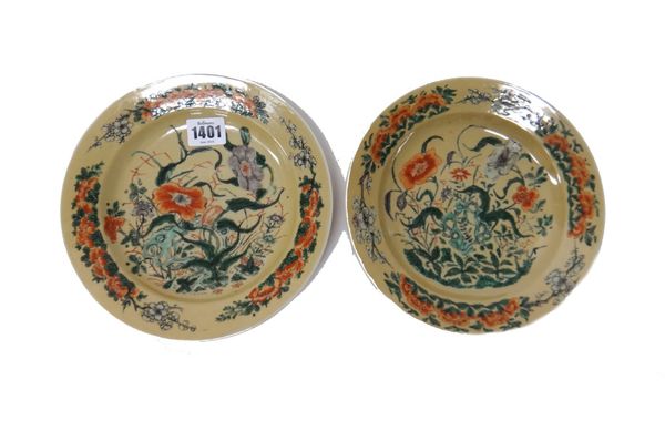 A pair of Chinese famille-verte plates, Kangxi painted with flowering shrubs against a cafe-au-lait ground, blue lotus marks, 20.5cm.diameter.