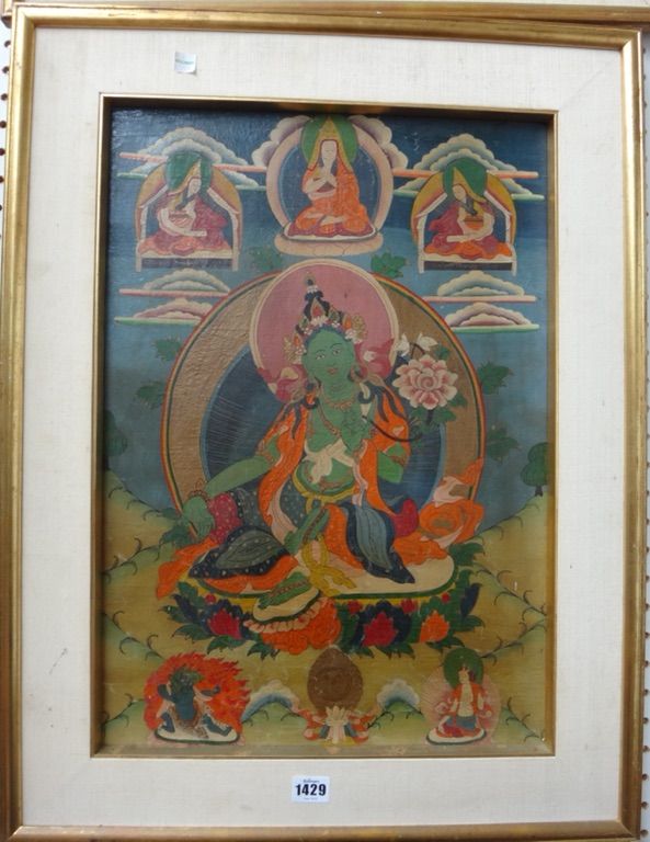 A Tibetan thangka, 19th century, painted with Green Tara seated on a lotus throne below three lamas, 54.5cm. by 38cm., in later frame.