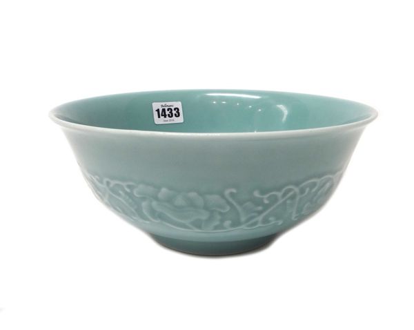A Chinese blue ground porcelain bowl, Daoguang seal mark but later, moulded on the exterior with trailing peony, with blue painted mark, 23.5cm. diame