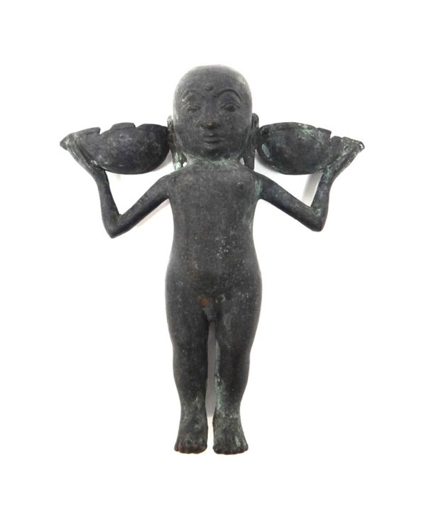 An Indian bronze oil lamp, probably 16th century, modelled as a standing boy supported two pans in his hands, 17cm.high.