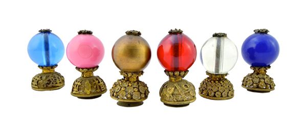 Six Chinese hat finials, 20th century, including one transparent blue glass button of the Third Rank, one transparent button of the Fifth Rank, an opa