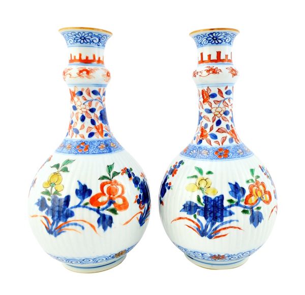 A pair of Chinese verte-Imari guglets, 18th century, each ribbed body painted in underglaze- blue, iron-red, gilt, green and yellow with sprays of flo