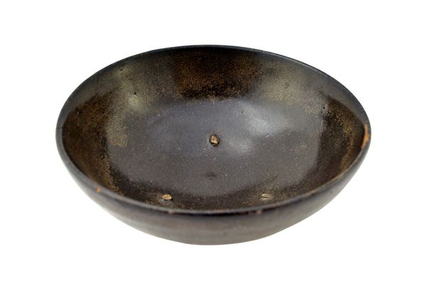 A Chinese black-glazed bowl, Song Dynasty, of shallow form, covered with a black-brown glaze suffused with `oil spots' beneath the rim, 16cm.diameter.