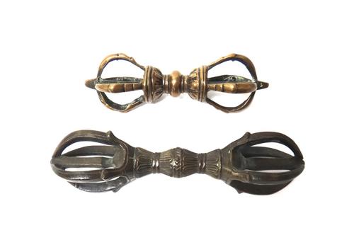 Two Tibetan bronze thunderbolts (vajra), 19th century, each with lightning bolts at each end, 12cm. and 14cm.length.