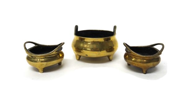 A Chinese bronze censer, Xuande mark but later, compressed form with upright loop handles and three peg feet, 9cm. wide across the handles; and a pair