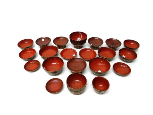 A group of fourteen Japanese lacquer bowls and seven covers, early 20th century, the exteriors decorated in gold lacquer and silvered highlights with