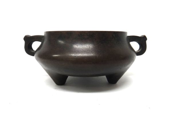 A Chinese bronze censer, six character Xuande mark, but later, compressed form set with two loop handles and raised on three peg feet, 18cm.across han
