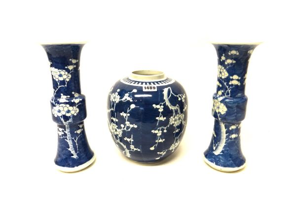 A pair of Chinese blue and white beaker vases and a ginger jar, circa 1900, each painted with branches of prunus blossom, vases 30cm. high, jar 23cm.