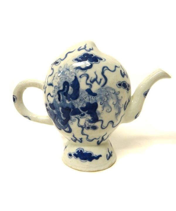 A Chinese blue and white cadogan teapot, 20th century, each side painted with a Buddhist lion amongst cloud scrolls, four character mark, 14cm. high.