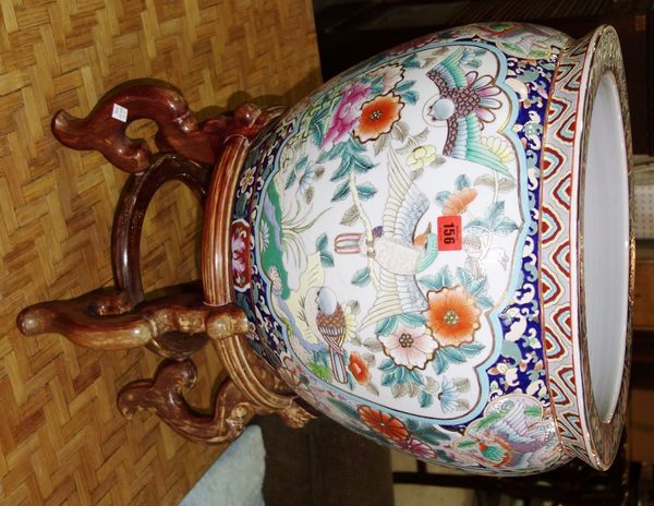 A large modern Chinese porcelain and enamel decorated fish bowl jardinière on stand, and another smaller bowl. (2)