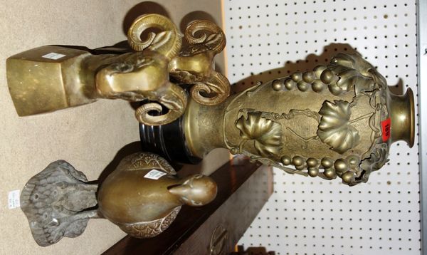 A brass vase moulded with fruit, together with a pair of spelter models of rams heads, and a brass model of a pigeon. (4)