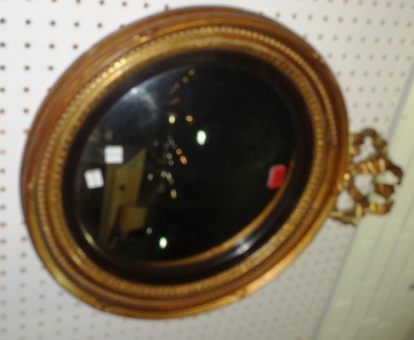 A circular gilt framed convex wall mirror with ribbon surmount, (1).