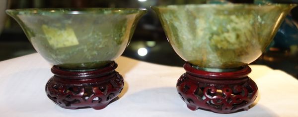 A pair of Oriental green hardstone bowls on stands. (2)
