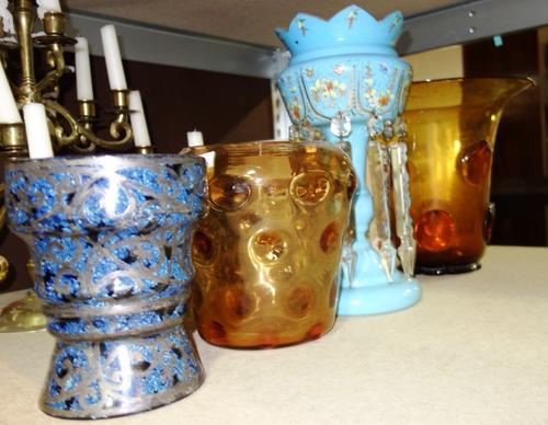 A blue glass lustre with cut glass drops, a blue marbled glass vase with silvered overlay decoration and two amber glass vases. (4)