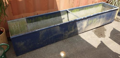 A single blue painted farm trough.
