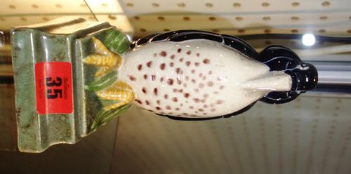 An early 20th century Delabasse pottery bookend, modelled as an exotic bird atop a plinth, 17cm high. (1)