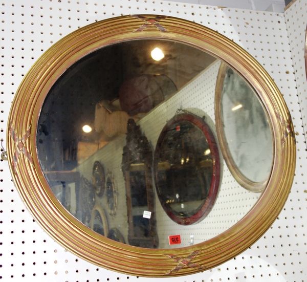 An oval gilt mirror with reeded decoration, 82cm wide x 79cm high.