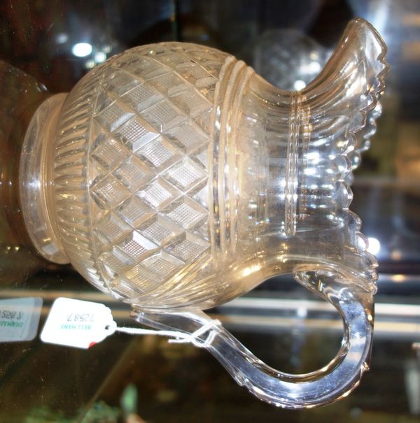 A cut glass jug, probably Irish, early 19th century, with shaped rim and polished base, 17.5cm high. (1)