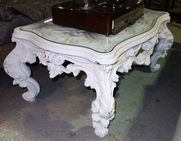 A heavily carved white painted coffee table with acanthus scrolling decoration, 100cm wide.