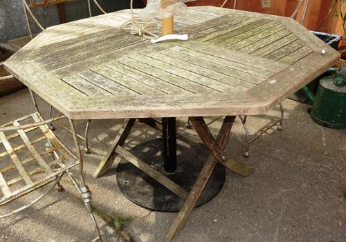 A 20th century teak circular garden table, and four folding chairs. (5)