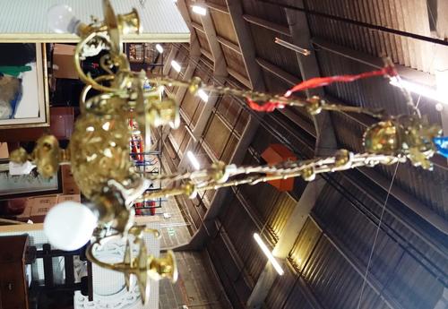 A  six branch brass chandelier of Victorian Gothic form, early 20th century, the foliate cast pierced bowl inset with coloured stones issuing six scon