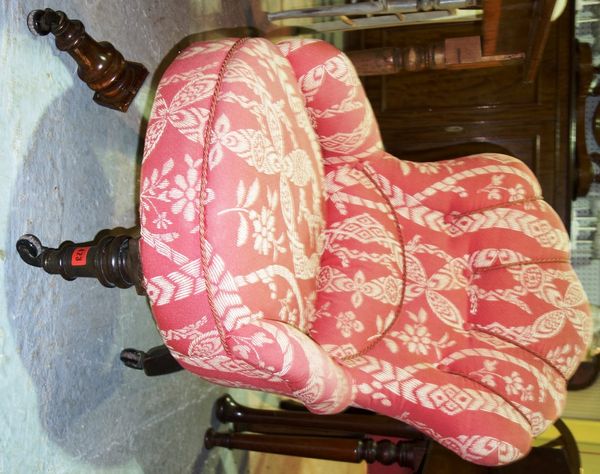 A Victorian shell back nursing chair on turned mahogany supports.
