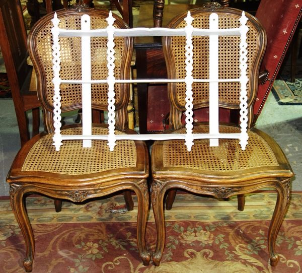 A pair of Louis XV style cane seated chairs and a white painted wall shelf. (3)