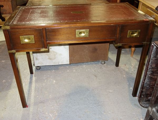 A mahogany campaign style writing desk with three drawers and red leather inset top, 107cm wide.