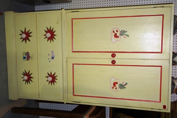 A 20th century yellow painted side cupboard with pair cupboard doors over two drawers 88cm wide.