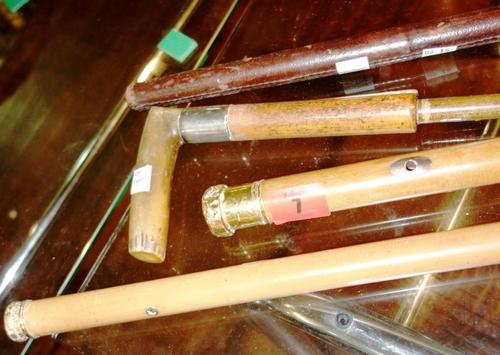 Two 20th century walking sticks with gold mounts and a silver mount walking stick handle, together with a leather swagger stick. (4)