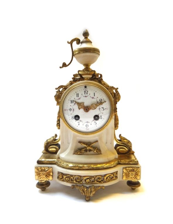 A French Empire style white marble and ormolu mounted mantel clock, late 19th century, with urn finial over a foliate decorated white enamel dial on a