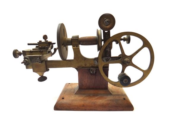 A brass watch maker's lathe, with fly pulley and adjustable stage, 36cm wide.