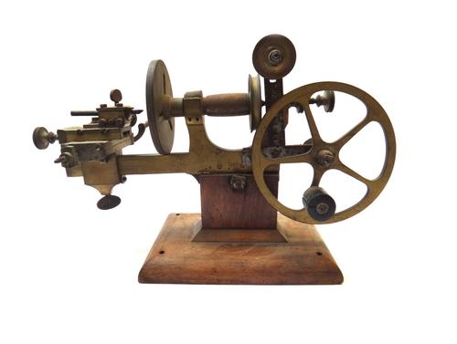 A brass watch maker's lathe, with fly pulley and adjustable stage, 36cm wide.