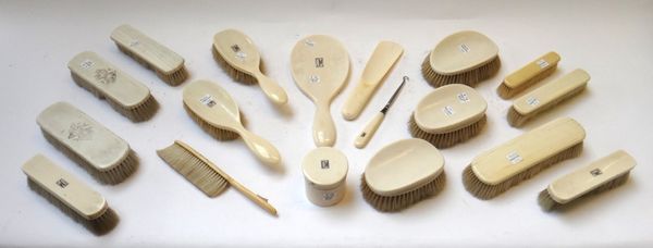 A Victorian ivory part dressing table set, including an oval hand mirror, a lidded pot and numerous brushes. (qty)