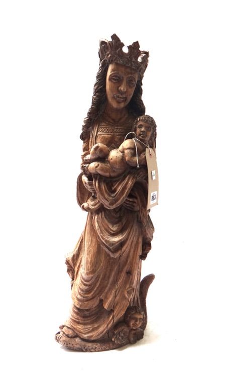 An 18th century style pine carving depicting Mary and the Holy Child, with serpent and angel masks to the base, 59cm high.
