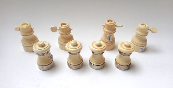 Four turned ivory and silver mounted pepper mills, early 20th century, together with four turned ivory salt cellars, 8.8cm high. (8)