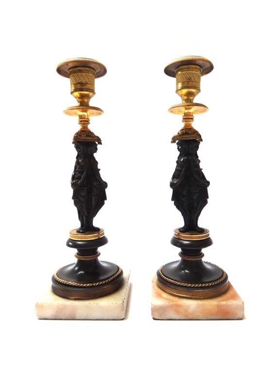 A pair of patinated and gilt bronze figural candlesticks, late 19th century, the circular sconce raised atop three classical female semi-nudes, on a c